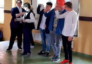 Grupa chłopców improwizuje śpiew na scenie.