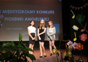 Uczennice biorące udział w konkursie pozują na scenie do zdjęcia.