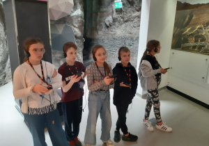 Uczniowie z słuchawkami na uszach biorą udział w interaktywnych zajęciach.