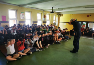 Pani policjant udziela dzieciom ważnych wskazówek, jak zachować się podczas ataku agresywnych psów.