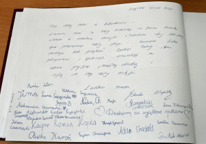Zdjęcie przedstawia wpis do księgi pamiątkowej wraz z podpisami uczniów.