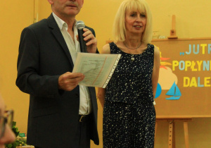 Wychowawca klasy siódmej oraz Pani Dyrektor wręczają świadectwa z wyróżnieniem.