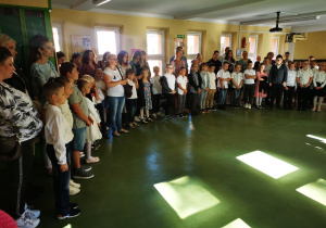 Odświętnie ubrani uczniowie najmłodszych klas na holu szkolnym.