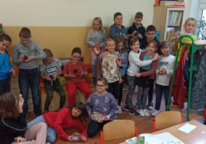 Dziewczynki i chłopcy pozują do zdjęcia podczas klasowego Dnia Chłopaka.