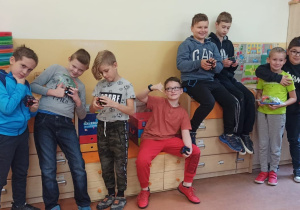 Grupa chłopców ogląda prezenty otrzymane z okazji Dnia Chłopaka.