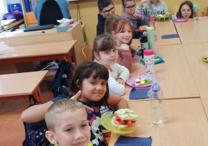 Uczniowie przy stole prezentują własne kanapki.