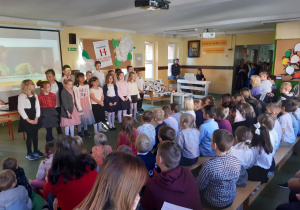 Klasa trzecia śpiewa piosenkę dla nauczycieli podczas przedstawienia z okazji Dnia Edukacji Narodowej.