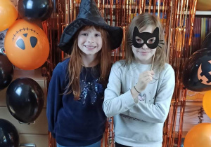 Uczennice na tle ścianki z napisem Happy Halloween.