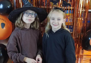 Uczennice na tle ścianki z napisem Happy Halloween.