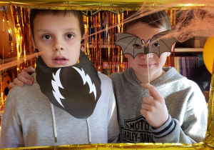 Uczniowie na tle dekoracji Halloweenowej pozują do zdjęcia.