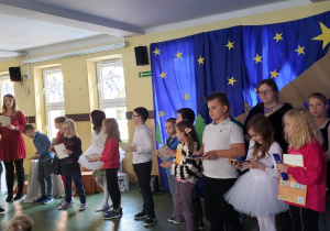 Laureaci konkursu stojący na szkolnym holu. Wręczenie nagród.