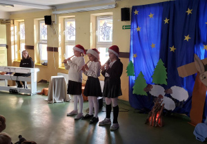 Trzy uczennice z klasy czwartej grają na fletach.
