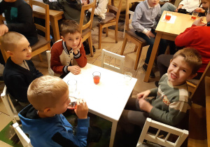 Uczniowie przy stoliku podczas poczęstunku w Baśniowej Kawiarence.