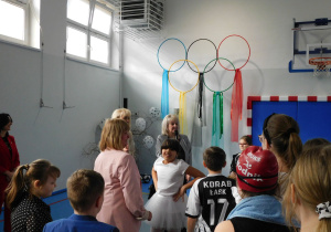 Pani Naczelnik Oświaty przemawia do dzieci na sali gimnastycznej.