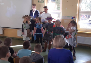 Uczniowie klasy pierwszej w strojach wykonanych z surowców wtórnych.