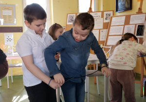 Uczniowie w grupach próbują wyplątać się ze sznurka bez użycia nożyczek.