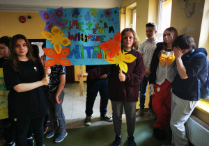 Uczniowie klasy ósmej prezentują plakat na powitanie wiosny.