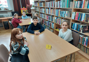 Uczestnicy konkursu siedzący przy stoliku podczas rozgrywek