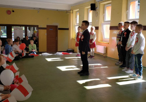 Uczeń klasy drugiej śpiewa pieśń patriotyczną podczas apelu z okazji 3 Maja.