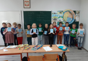 Uczniowie klasy pierwszej pozują do zdjęcia z otrzymanymi dyplomami w konkursie.