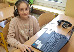 Uczennica przy komputerze rozwiązuje zadania konkursowe.