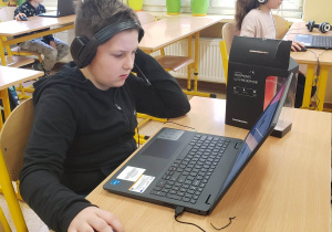 Uczeń przy komputerze rozwiązuje zadania konkursowe.