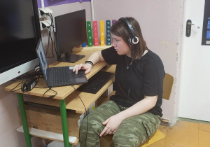 Uczennica przy komputerze rozwiązuje zadania konkursowe.