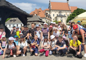 Uczestnicy wycieczki pozują do zdjęcia grupowego na rynku w Kazimierzu Dolnym.