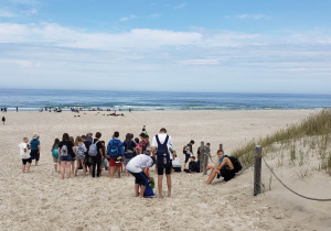 Uczestnicy wycieczki na plaży. W tle morze.