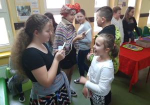 Podczas przerwy starsi uczniowie wróżą z kart młodszym dzieciom.
