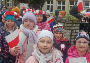 Dzieci gromadzą się przed budynkiem szkoły, aby wyruszyć na marsz z okazji Święta 11 listopada.