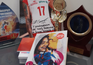 Zdjęcie z autografem polskiej siatkarki Malwiny Smarzek oraz jej trofea sportowe.