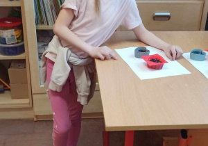 Uczennica z dumą prezentuje własne mydełko leżące na stoliku.