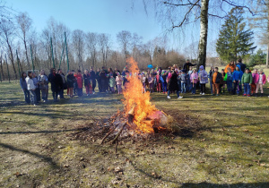Uczniowie szkoły gromadzą sie wokół ogniska.