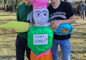 Dwóch uczniów prezentuje marzannę.