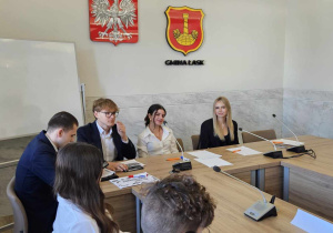 Przedstawiciele Młodzieżowej Rady Miejskiej siedzą w sali urzędu miejskiego podczas spotkania z przedstawicielami samorządów uczniowskich.
