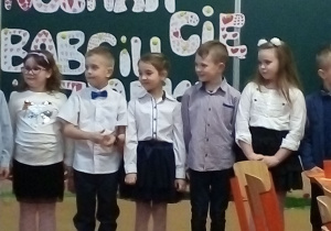 Uczniowie klasy pierwszej podczas przedstawienie dla goszczących w klasie babć i dziadków.