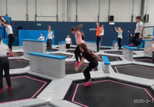 Dzieci skaczą na trampolinach.