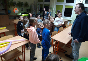 W pracowni przyrodniczej dzieci słuchają pana od przyrody.