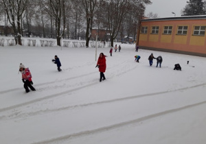 Dzieci bawiące się na śniegu.