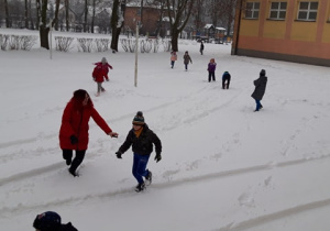 Dzieci bawiące się na śniegu.