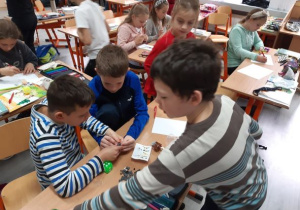 Chłopcy z klasy trzeciej bawią się klockami.