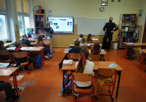Uczniowsie klasy drugiej słuchają wystąpienia pana policjanta.