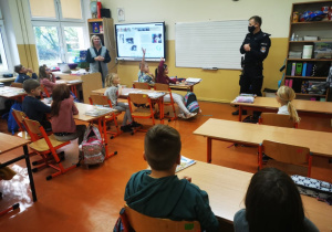 Uczniowie klasy drugiej słuchają wystąpienia pana policjanta.