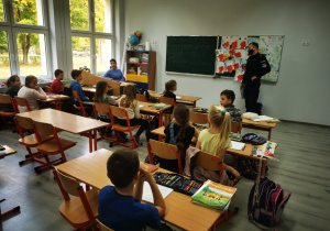 Uczniowsie klasy trzeciej słuchają wystąpienia pana policjanta.