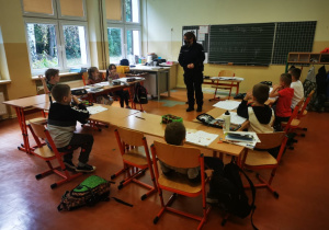 Uczniowie klasy pierwszej słuchają wystapienia pani policjantki.