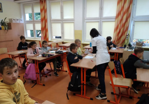 Pani dietetyk pomaga uczniom podczas udzielania odpowiedzi do ankiety.