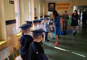 Wychowawczyni klasy pierwszej wręcza każdemu uczniowi pamiątkę ślubowania.