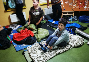 Uczniowie na materacach podczas nocowania w szkole.