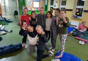 Uczennice klasy trzeciej pozują do zdjęcia podczas nocowania w szkole.